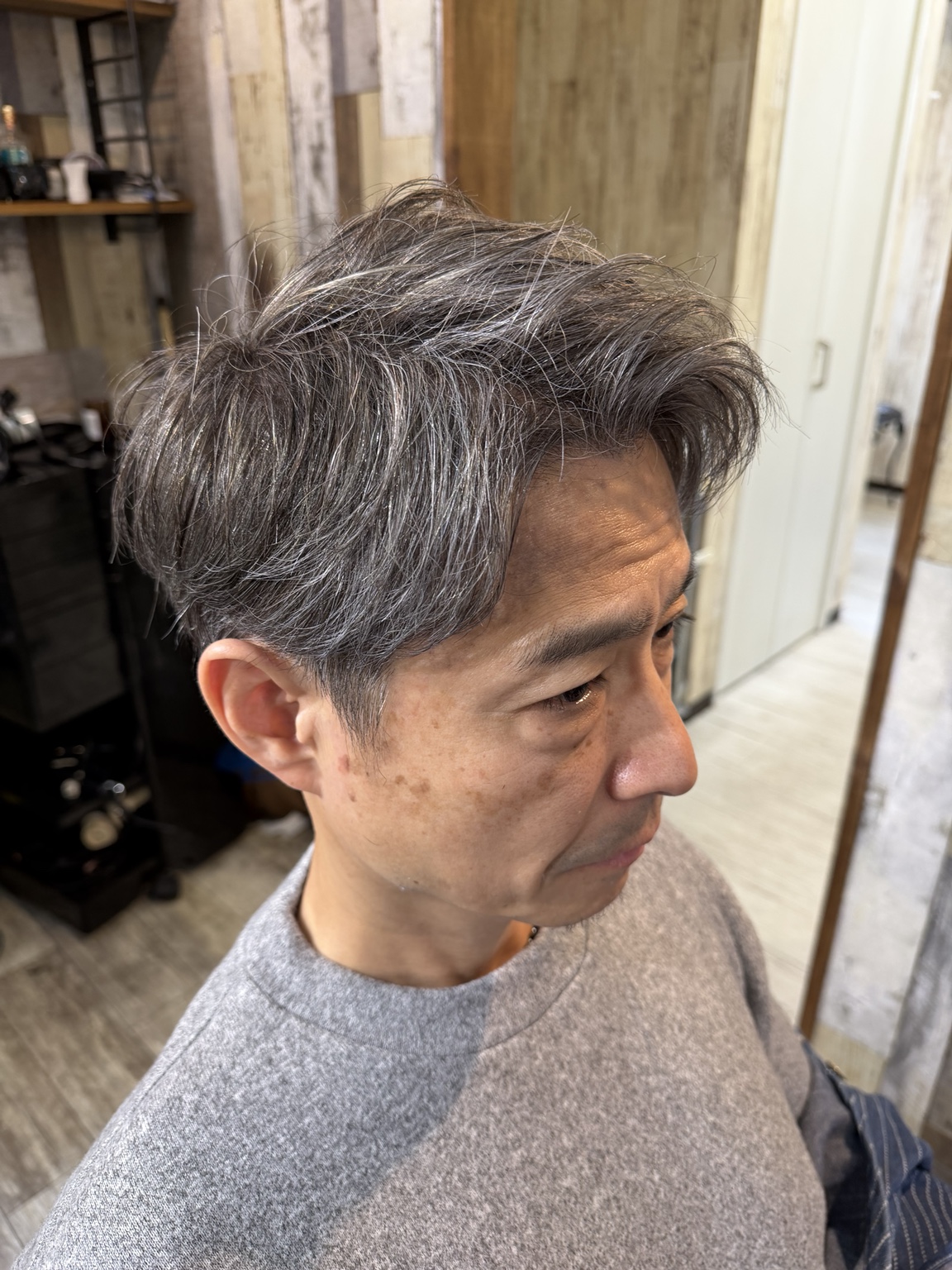 自然なグレイヘアを活かした、清潔感のあるメンズスタイルの仕上がり
