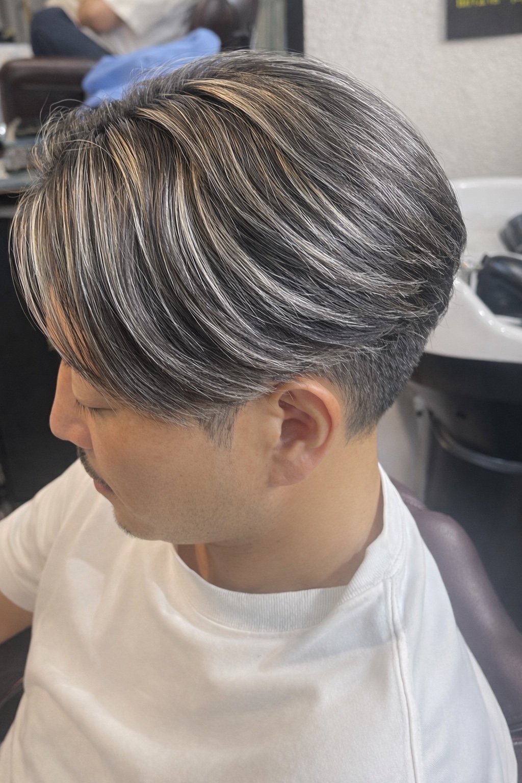 シルバーヘアと明るい毛束がなじむ、毛流れを活かしたメンズスタイル